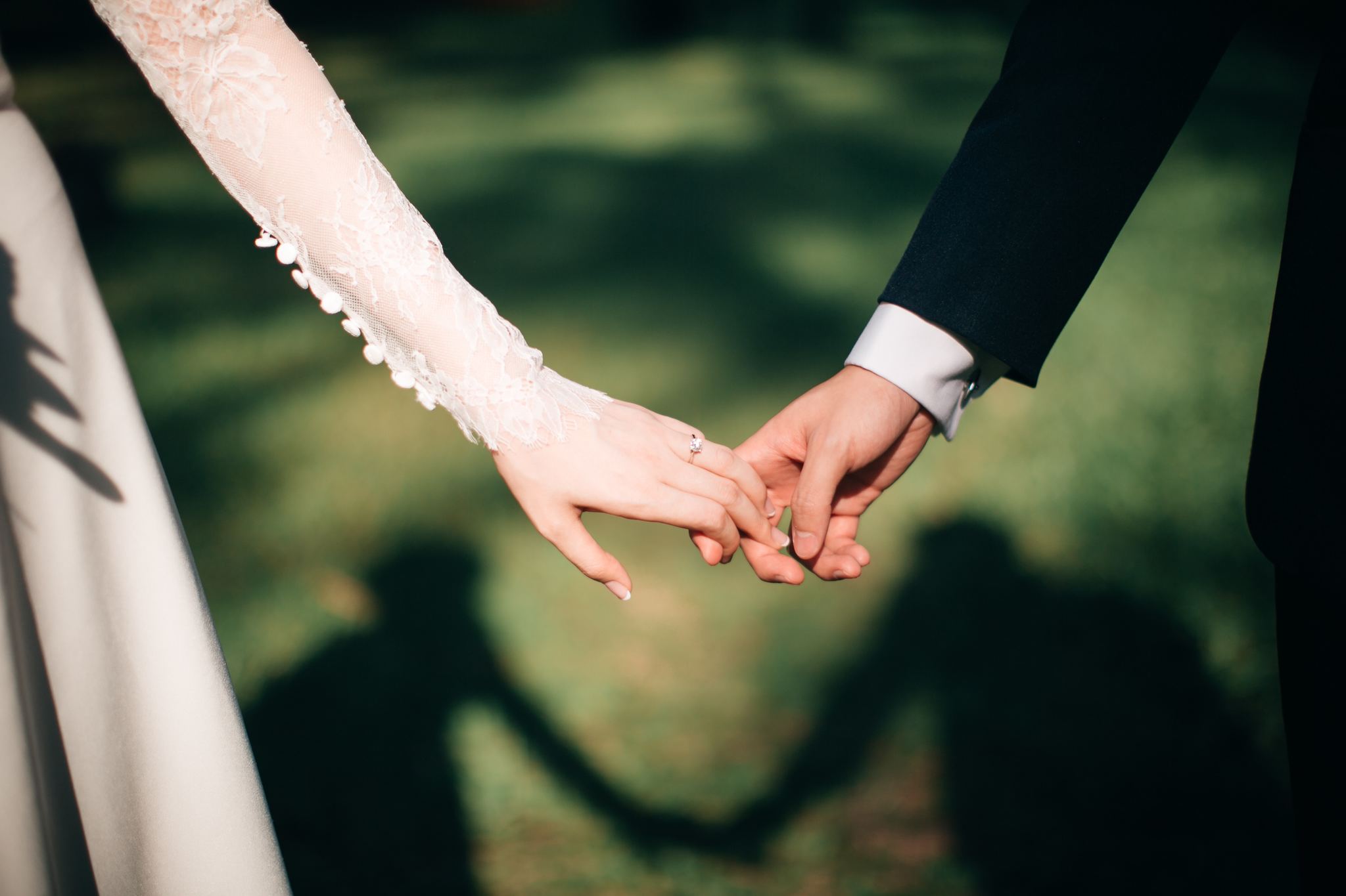 Closeup of newlyweds holding hands on their wedding day